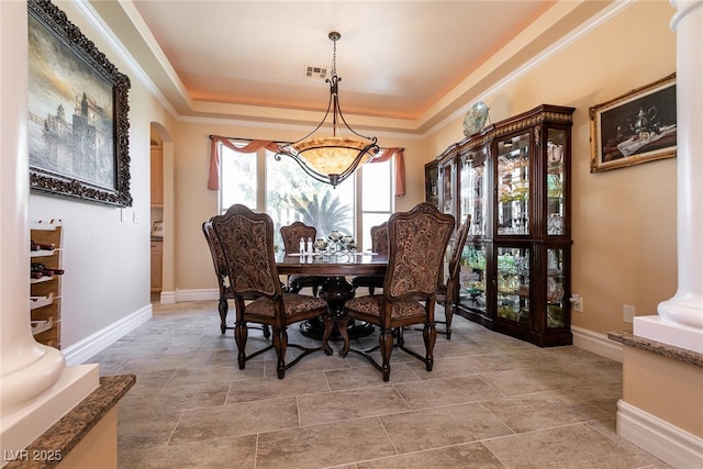7718 Willow Cove Cir, Las Vegas, NV 89129 - dining space with a tray ceiling, arched walkways, a chandelier, baseboards, and crown molding