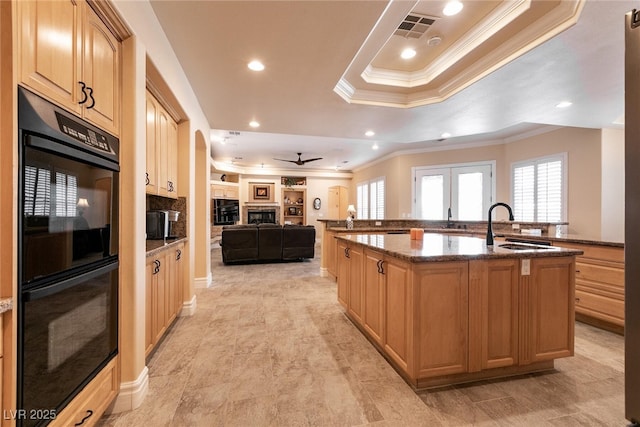 7718 Willow Cove Cir, Las Vegas, NV 89129 - kitchen featuring crown molding, a sink, an island with sink, a fireplace, and ceiling fan