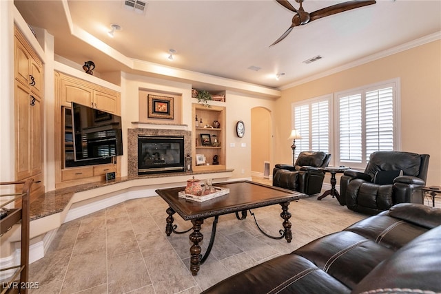 7718 Willow Cove Cir, Las Vegas, NV 89129 - living area with arched walkways, ceiling fan, built in features, ornamental molding, and light tile patterned flooring