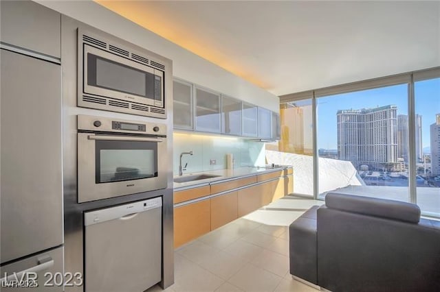 3722 Las Vegas Blvd Unit 603, Las Vegas, NV 89158 - kitchen with built in appliances, a sink, light countertops, glass insert cabinets, and a city view