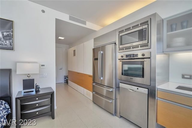 3722 Las Vegas Blvd Unit 603, Las Vegas, NV 89158 - kitchen featuring appliances with stainless steel finishes, light countertops, and glass insert cabinets