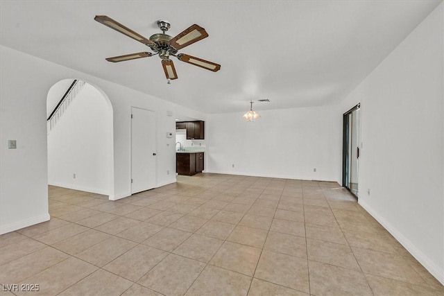 3935 Tirana Way, Las Vegas, NV 89103 - unfurnished living room featuring a ceiling fan, a sink, light tile patterned flooring, and arched walkways
