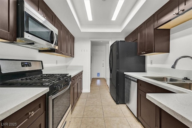 3935 Tirana Way, Las Vegas, NV 89103 - kitchen featuring appliances with stainless steel finishes, a sink, a raised ceiling, dark brown cabinetry, and light tile patterned flooring