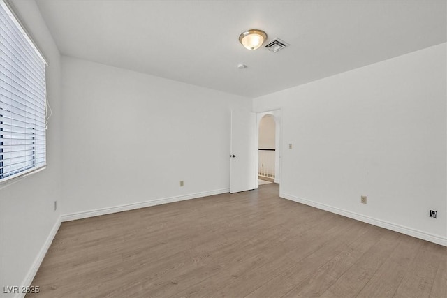 3935 Tirana Way, Las Vegas, NV 89103 - unfurnished room with arched walkways, wood finished floors, healthy amount of natural light, and baseboards
