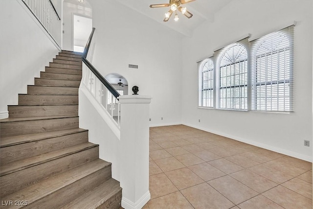 3935 Tirana Way, Las Vegas, NV 89103 - stairway featuring ceiling fan, tile patterned flooring, high vaulted ceiling, healthy amount of natural light, and baseboards