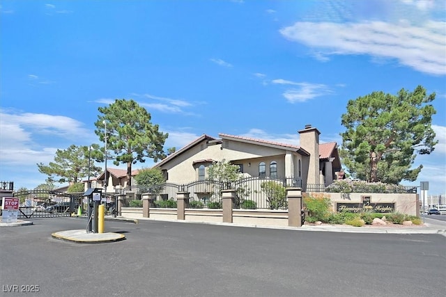 3935 Tirana Way, Las Vegas, NV 89103 - view of front of property featuring a gate, a chimney, and stucco siding