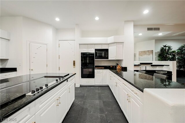 2231 S Tioga Way, Las Vegas, NV 89117 - kitchen with black appliances, white cabinetry, dark stone countertops, recessed lighting, and dark tile patterned floors