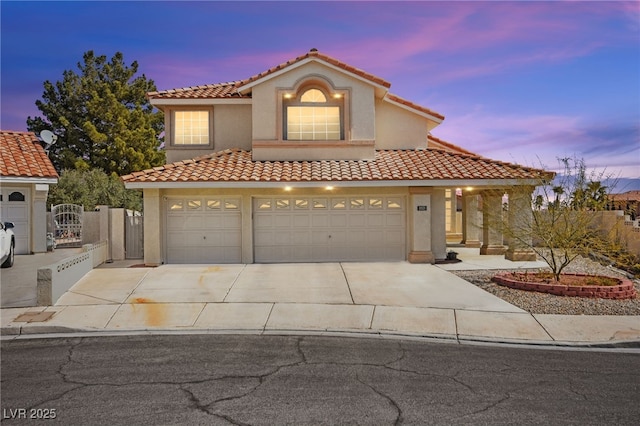 2021 Summit Pointe Dr, Las Vegas, NV 89117 - mediterranean / spanish-style house featuring concrete driveway, a tiled roof, stucco siding, and a garage