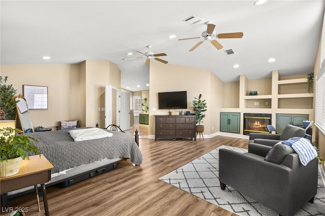 2021 Summit Pointe Dr, Las Vegas, NV 89117 - bedroom with vaulted ceiling, wood finished floors, a glass covered fireplace, baseboards, and recessed lighting