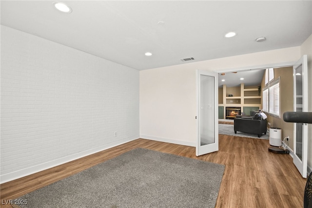 2021 Summit Pointe Dr, Las Vegas, NV 89117 - living room with brick wall, baseboards, wood finished floors, a glass covered fireplace, and recessed lighting