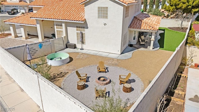 2021 Summit Pointe Dr, Las Vegas, NV 89117 - back of property with a patio area, a tile roof, a fire pit, stucco siding, and a fenced backyard