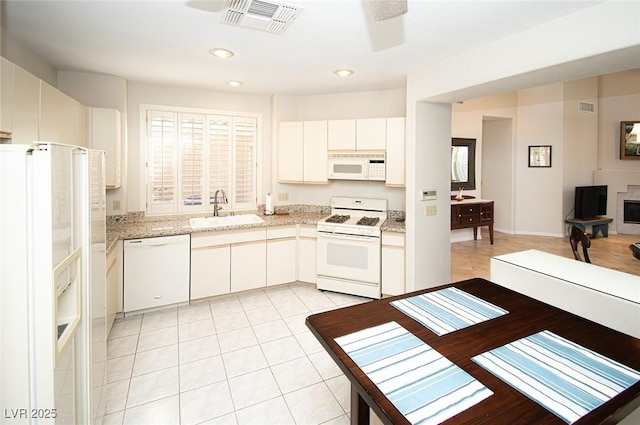 4911 Mount Pleasant Ln, Las Vegas, NV 89113 - kitchen featuring white appliances, a sink, white cabinets, light stone countertops, and recessed lighting