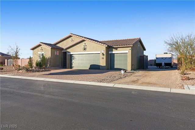 42 Late Harvest Ave, Pahrump, NV 89060 - mediterranean / spanish-style home with driveway, stucco siding, a garage, and a tiled roof