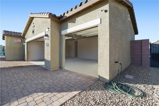42 Late Harvest Ave, Pahrump, NV 89060 - view of side of home featuring stucco siding, a tile roof, and a garage