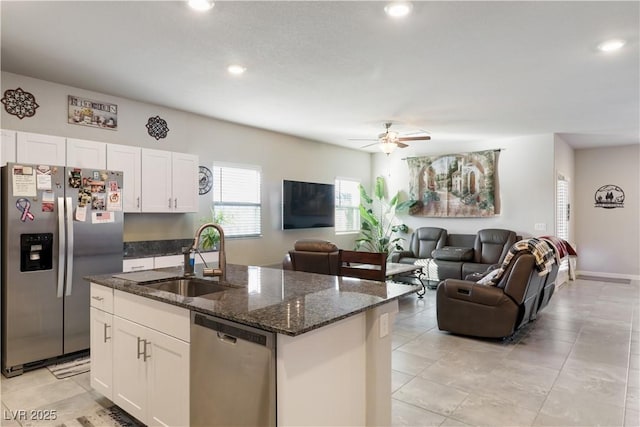 42 Late Harvest Ave, Pahrump, NV 89060 - kitchen with appliances with stainless steel finishes, a sink, an island with sink, dark stone countertops, and white cabinetry