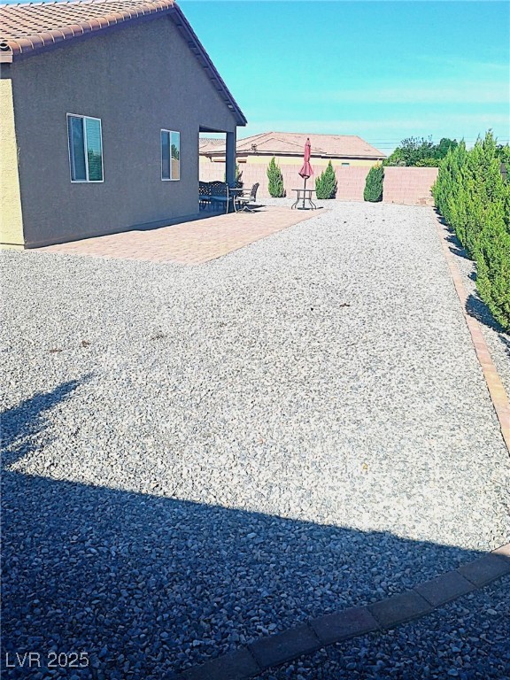42 Late Harvest Ave, Pahrump, NV 89060 - view of property exterior with a patio area, stucco siding, a fenced backyard, and a tile roof