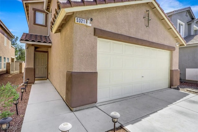 5321 Welch Valley Ave, Las Vegas, NV 89131 - view of front of house with stucco siding, a tile roof, a garage, and driveway