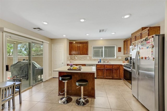 5321 Welch Valley Ave, Las Vegas, NV 89131 - kitchen with appliances with stainless steel finishes, a sink, light countertops, decorative backsplash, and brown cabinets