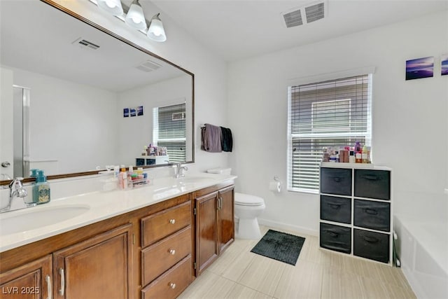 5321 Welch Valley Ave, Las Vegas, NV 89131 - full bathroom featuring double vanity, healthy amount of natural light, a garden tub, and toilet