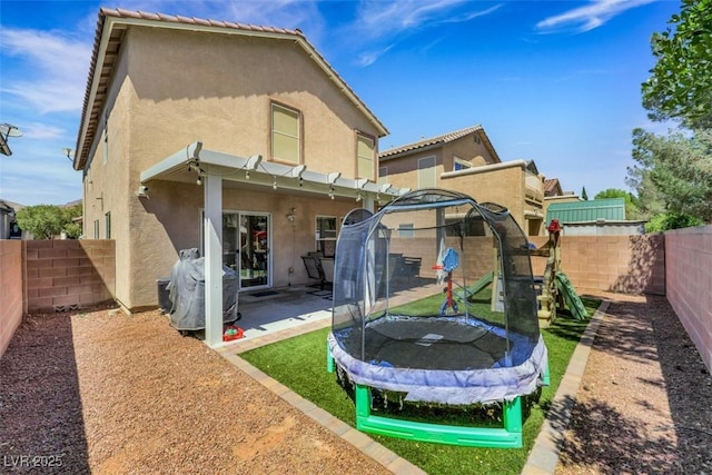 5321 Welch Valley Ave, Las Vegas, NV 89131 - back of house with a trampoline, stucco siding, a patio, and a fenced backyard