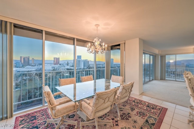 3111 Bel Air Dr Unit 23A, Las Vegas, NV 89109 - dining space with a chandelier, light tile patterned floors, expansive windows, a view of city, and light carpet