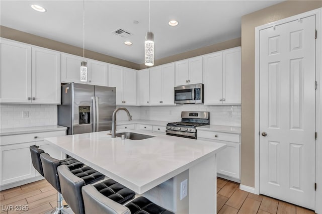 688 Monroe Hill Pl, Henderson, NV 89011 - kitchen featuring stainless steel appliances, a sink, wood finish floors, light countertops, and recessed lighting
