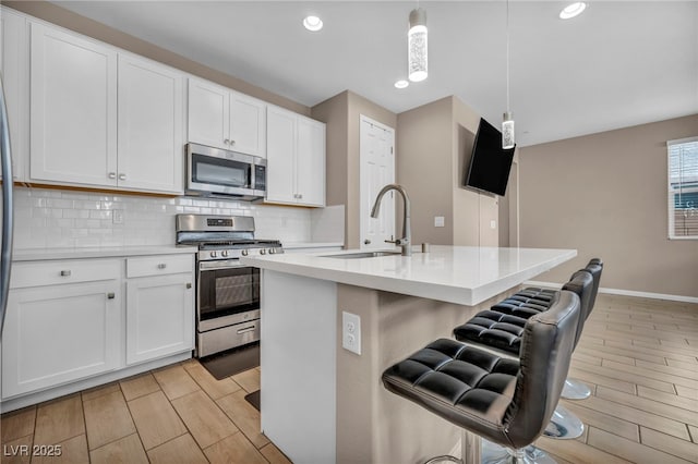 688 Monroe Hill Pl, Henderson, NV 89011 - kitchen featuring stainless steel appliances, a sink, tasteful backsplash, a breakfast bar area, and light countertops