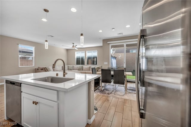 688 Monroe Hill Pl, Henderson, NV 89011 - kitchen with stainless steel refrigerator, a sink, wood finish floors, open floor plan, and plenty of natural light