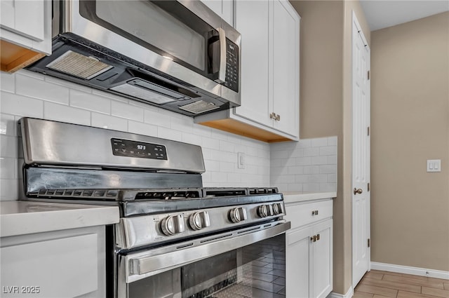 688 Monroe Hill Pl, Henderson, NV 89011 - kitchen featuring appliances with stainless steel finishes, white cabinetry, light countertops, and backsplash
