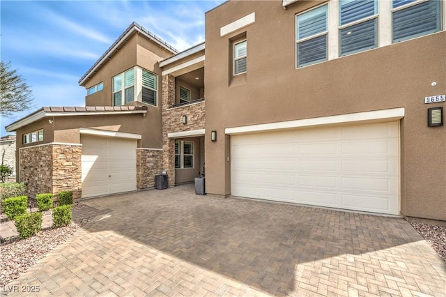 9655 Skye Star Ave, Las Vegas, NV 89166 - multi unit property featuring stone siding, an attached garage, stucco siding, and decorative driveway