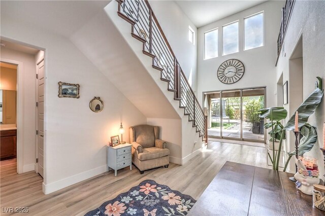 9655 Skye Star Ave, Las Vegas, NV 89166 - sitting room featuring stairway, wood finished floors, baseboards, and a towering ceiling
