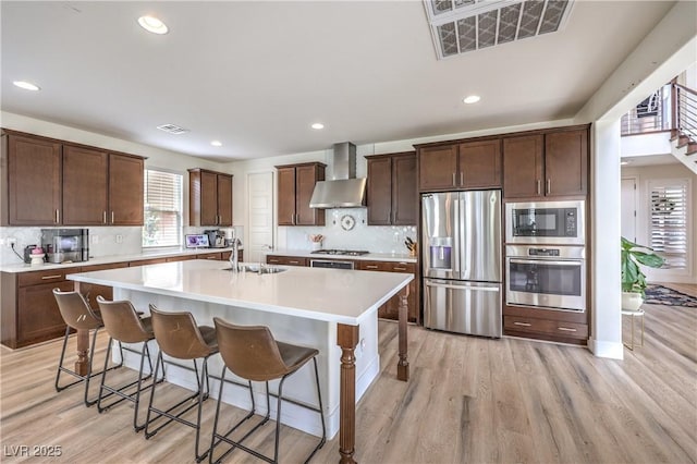 9655 Skye Star Ave, Las Vegas, NV 89166 - kitchen featuring stainless steel appliances, wall chimney range hood, a sink, light countertops, and recessed lighting