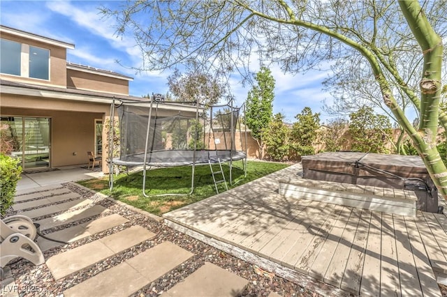 9655 Skye Star Ave, Las Vegas, NV 89166 - fenced backyard with a covered hot tub, a patio, a trampoline, and a wooden deck