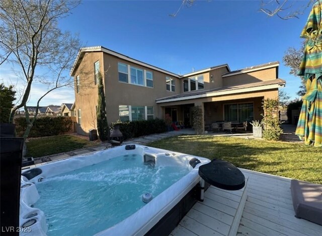 9655 Skye Star Ave, Las Vegas, NV 89166 - back of property with an outdoor hot tub, stucco siding, a wooden deck, and a yard