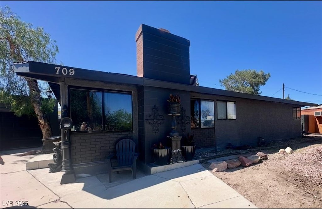 709 Evergreen Cir, Las Vegas, NV 89107 - view of front of property featuring a chimney, a patio, and brick siding