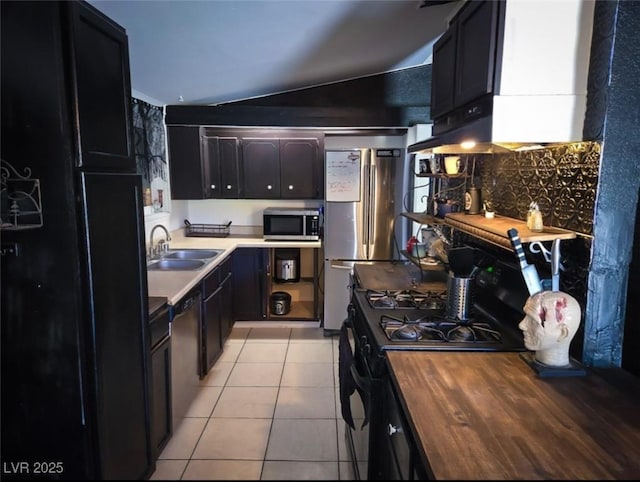 709 Evergreen Cir, Las Vegas, NV 89107 - kitchen with appliances with stainless steel finishes, a sink, light tile patterned floors, lofted ceiling, and decorative backsplash
