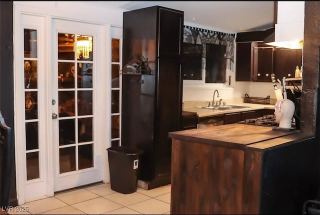 709 Evergreen Cir, Las Vegas, NV 89107 - kitchen featuring wood counters, a sink, light tile patterned floors, and cooktop