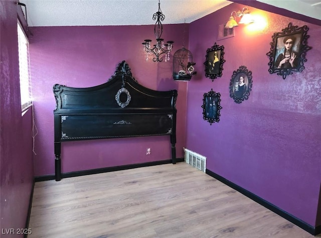 709 Evergreen Cir, Las Vegas, NV 89107 - bedroom featuring wood finished floors, baseboards, and a chandelier