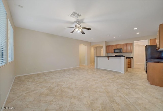 11441 Drappo Ave, Las Vegas, NV 89138 - kitchen with black microwave, arched walkways, dark countertops, ceiling fan, and open floor plan