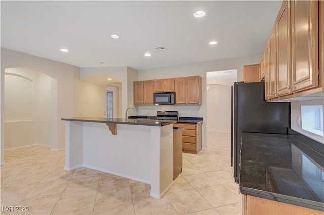 11441 Drappo Ave, Las Vegas, NV 89138 - kitchen featuring black appliances, arched walkways, recessed lighting, light tile patterned floors, and an island with sink