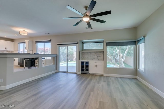 10908 Royal Highlands St, Las Vegas, NV 89141 - unfurnished living room with wine cooler, light wood-type flooring, healthy amount of natural light, ceiling fan, and recessed lighting