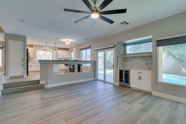 10908 Royal Highlands St, Las Vegas, NV 89141 - unfurnished living room with wine cooler, a ceiling fan, light wood-style floors, baseboards, and recessed lighting