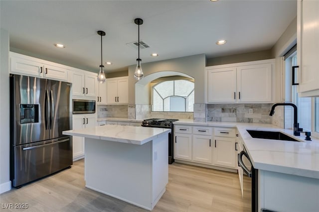 10908 Royal Highlands St, Las Vegas, NV 89141 - kitchen with appliances with stainless steel finishes, a sink, light stone countertops, white cabinetry, and light wood-style floors