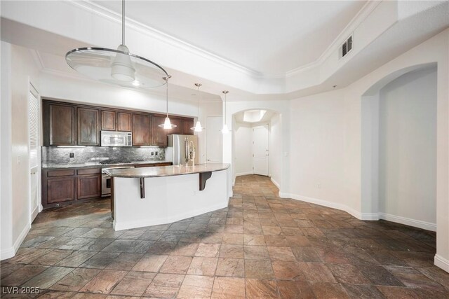 68 E Serene Ave Unit 224, Las Vegas, NV 89123 - kitchen featuring stainless steel appliances, stone tile floors, arched walkways, baseboards, and ornamental molding