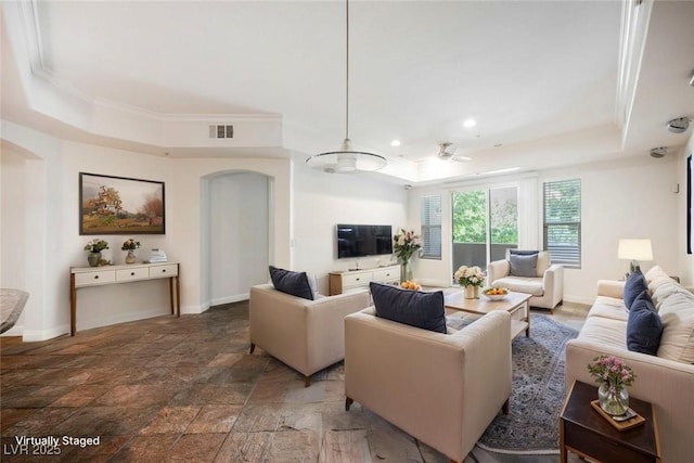 68 E Serene Ave Unit 224, Las Vegas, NV 89123 - living area featuring a tray ceiling, arched walkways, baseboards, ornamental molding, and light stone finish floors