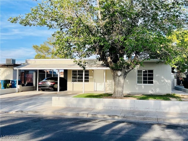700 N Minnesota St, Las Vegas, NV 89107 - single story home with concrete driveway, an attached carport, stucco siding, and central AC unit