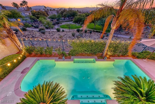 3050 Whispering Crest Dr, Henderson, NV 89052 - pool at dusk with a mountain view and a putting green