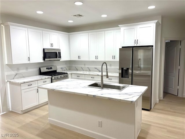7615 Paso Robles Ave, Las Vegas, NV 89113 - kitchen with appliances with stainless steel finishes, a sink, light wood finished floors, white cabinets, and recessed lighting