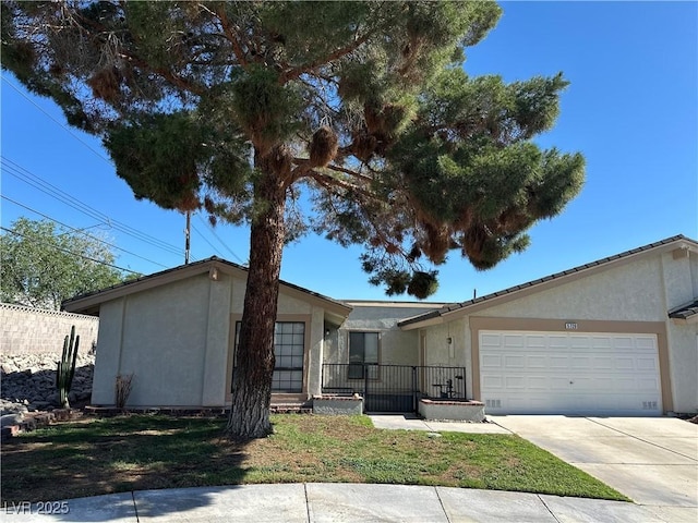 5720 Goldmount Ave, Las Vegas, NV 89107 - view of front of property with stucco siding, an attached garage, and concrete driveway
