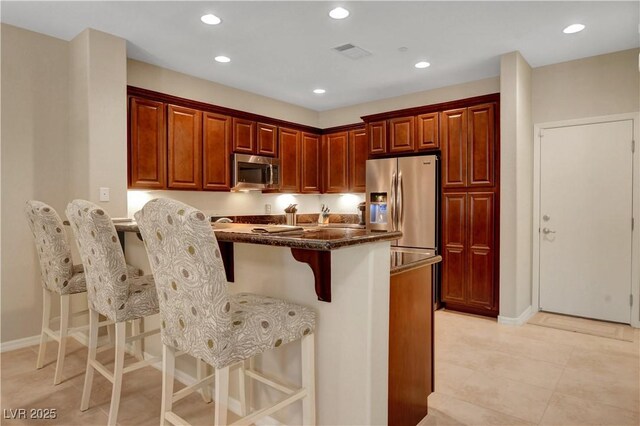1560 Plaza Centre Dr Unit 103, Las Vegas, NV 89135 - kitchen featuring appliances with stainless steel finishes, a kitchen breakfast bar, a peninsula, recessed lighting, and baseboards